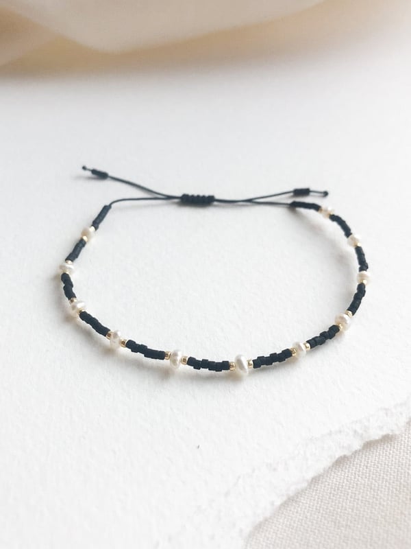 Pleciona czarna bransoletka perełkami i złotymi koralikami