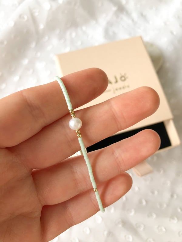 Pleciona czarna bransoletka z jedną perełką i złotymi koralikami