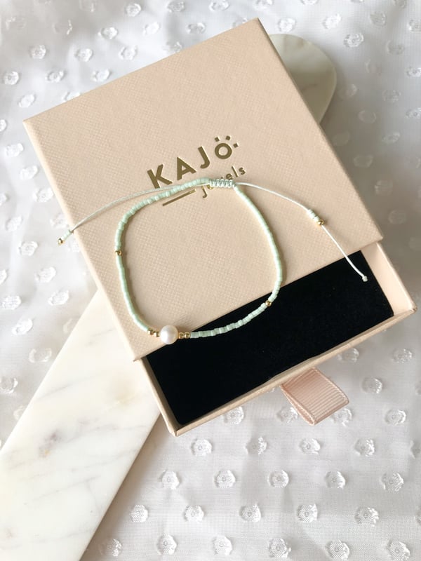 Pleciona czarna bransoletka z jedną perełką i złotymi koralikami