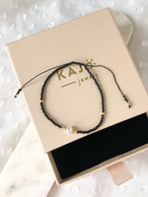 Pleciona czarna bransoletka z jedną perełką i złotymi koralikami