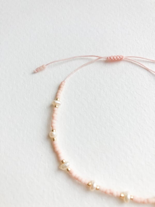 Pleciona różowa bransoletka perełkami i złotymi koralikami