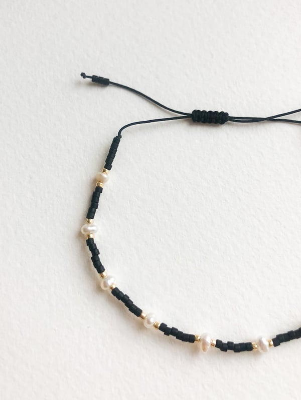 Pleciona czarna bransoletka perełkami i złotymi koralikami