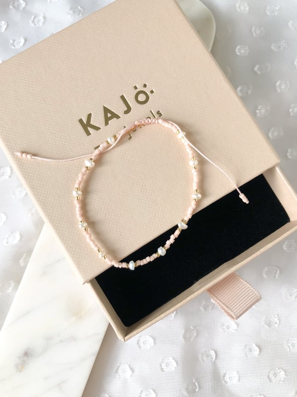 Pleciona różowa bransoletka perełkami i złotymi koralikami