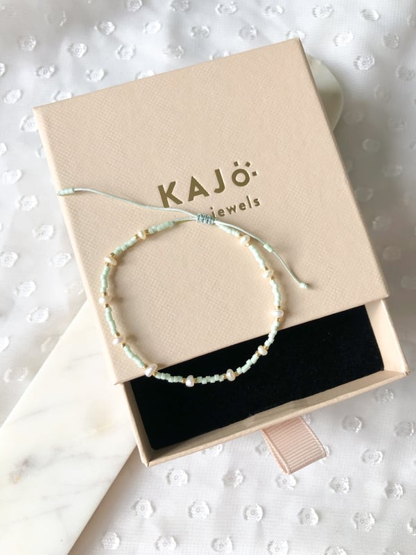 Pleciona miętowa bransoletka z jedną perełką i złotymi koralikami