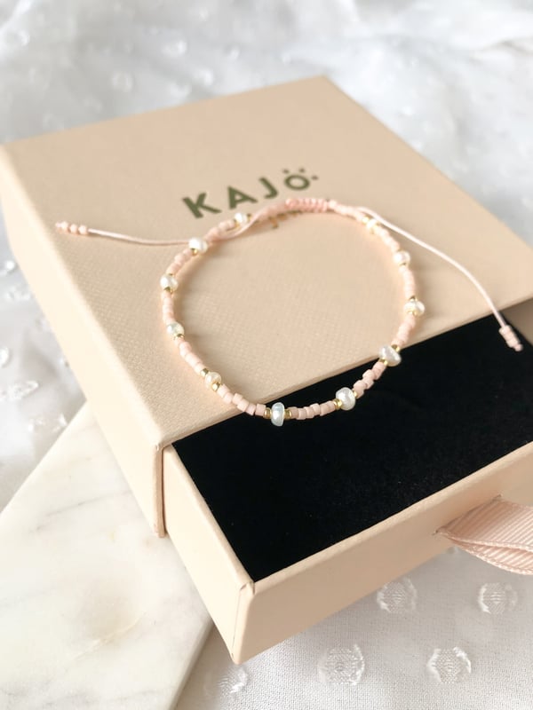 Pleciona różowa bransoletka perełkami i złotymi koralikami