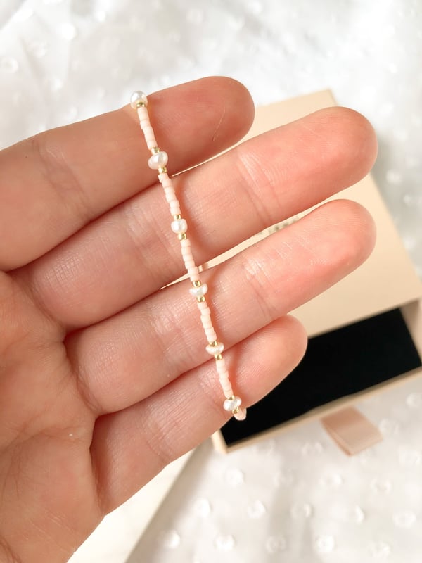 Pleciona różowa bransoletka perełkami i złotymi koralikami